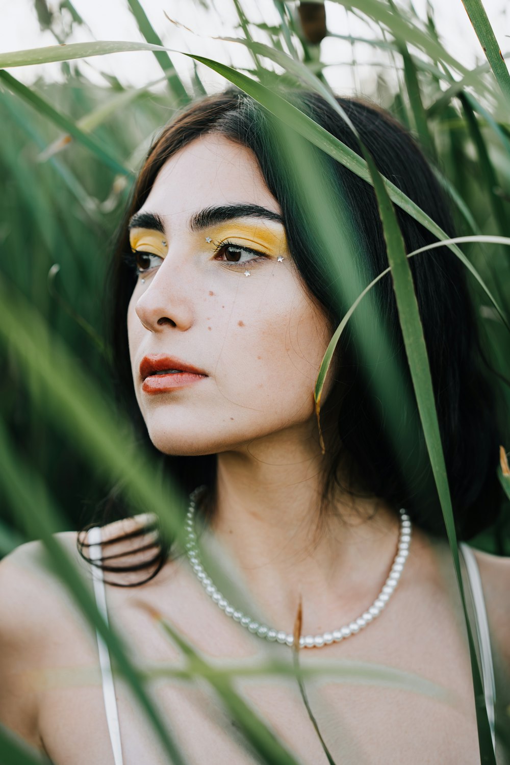 a woman wearing a necklace and a pearl necklace