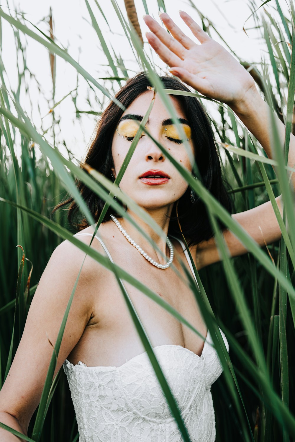 a woman in a white dress standing in tall grass