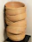Stacked nesting storage baskets made of woven material sitting neatly on a hardwood floor.