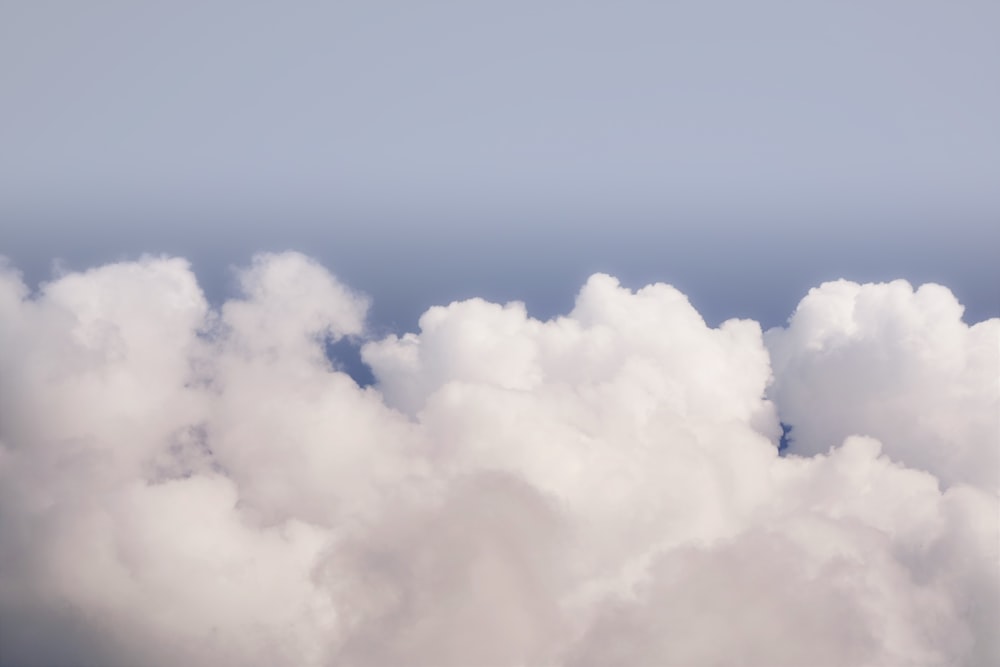 a plane flying through a cloud filled sky