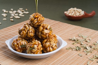Close-up of fresh peanuts and golden jaggery cubes arranged on rustic wooden table.