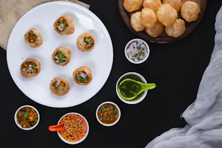 a white plate topped with food next to bowls of dipping sauce