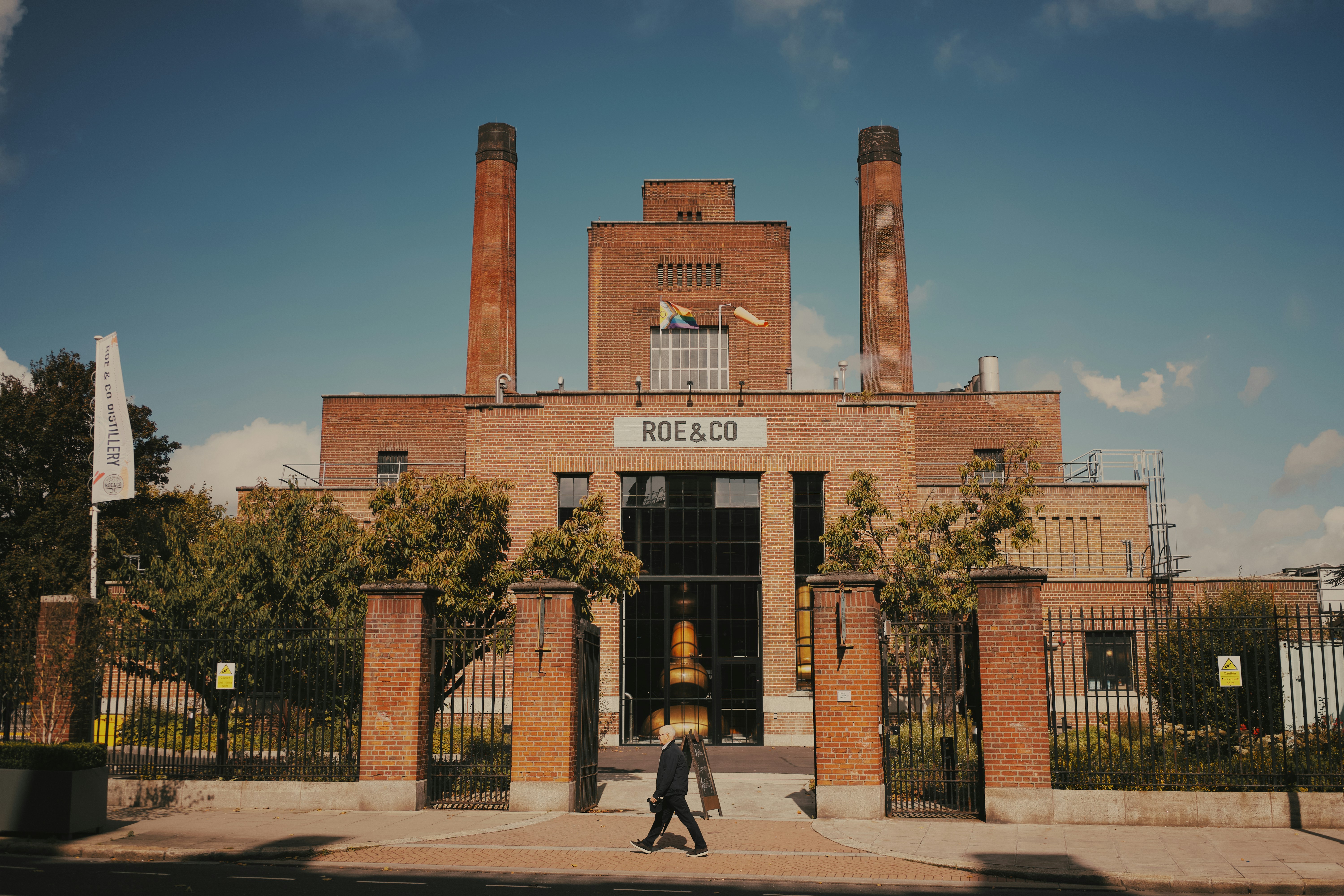 a man walking in front of a brick building