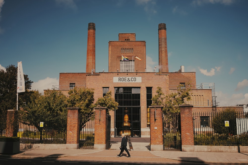 a man walking in front of a brick building