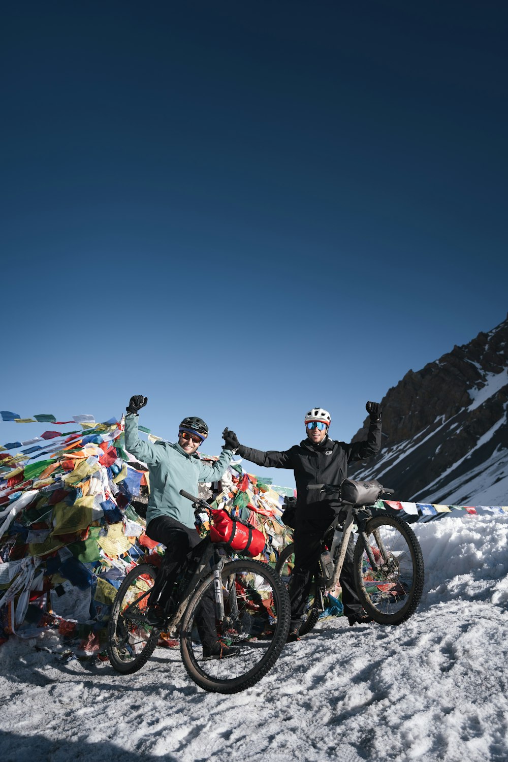 a couple of people that are on some bikes in the snow