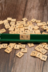 scrabble tiles spelling out the word ai on a wooden table