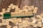 Wooden letter tiles scattered across a wooden surface, with a green tile holder displaying the word 'PODCAST' spelled out prominently.