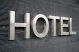 Large metallic letters spelling 'HOTEL' are mounted on a textured dark surface.