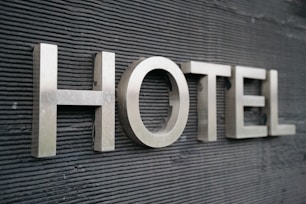 Large metallic letters spelling 'HOTEL' are mounted on a textured dark surface.
