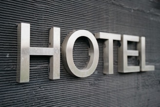 Large metallic letters spelling 'HOTEL' are mounted on a textured dark surface.