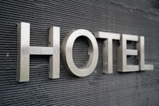 Large metallic letters spelling 'HOTEL' are mounted on a textured dark surface.