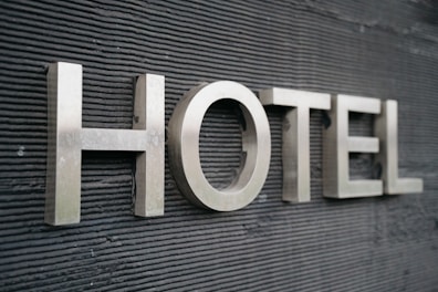 Large metallic letters spelling 'HOTEL' are mounted on a textured dark surface.