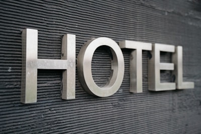 Large metallic letters spelling 'HOTEL' are mounted on a textured dark surface.