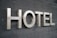 Large metallic letters spelling 'HOTEL' are mounted on a textured dark surface.