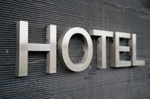 Large metallic letters spelling 'HOTEL' are mounted on a textured dark surface.