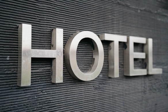 Large metallic letters spelling 'HOTEL' are mounted on a textured dark surface.