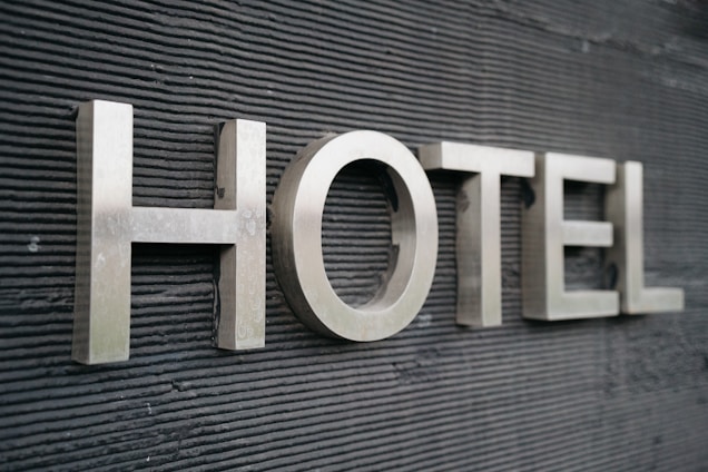 Large metallic letters spelling 'HOTEL' are mounted on a textured dark surface.