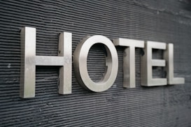 Large metallic letters spelling 'HOTEL' are mounted on a textured dark surface.