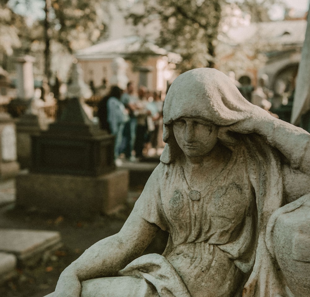 a statue of a woman sitting in a cemetery