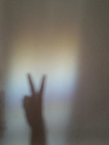 A friendly hand waving against a soft pastel background.