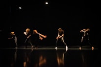 Close-up of dancers’ expressive faces mid-performance on stage.