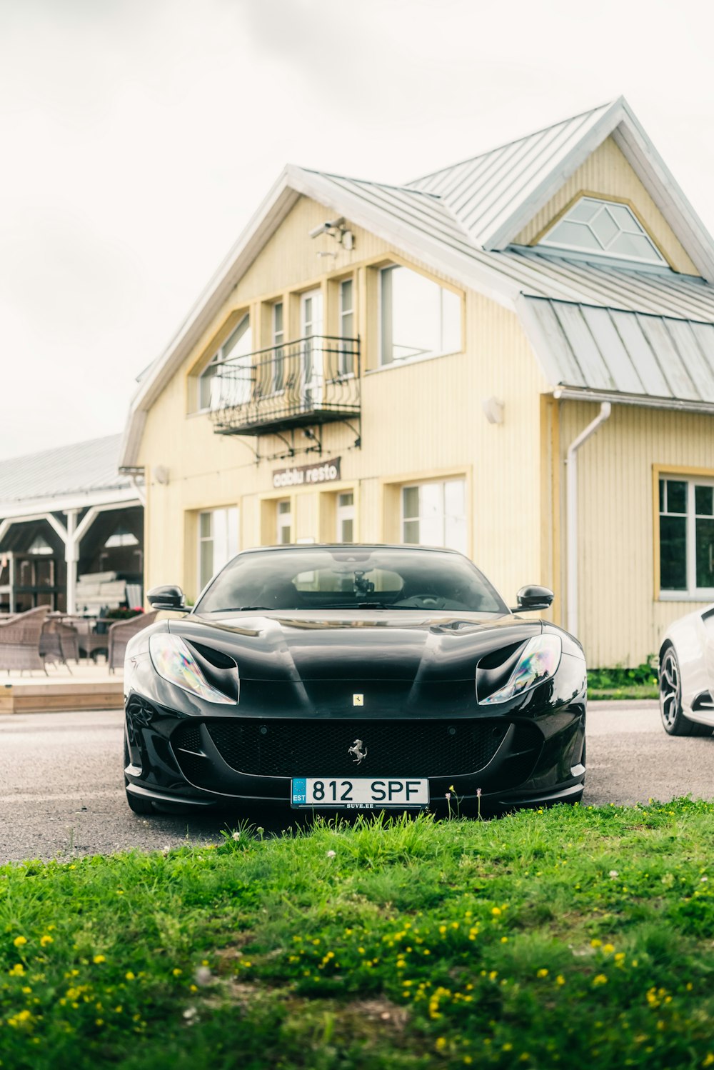 a black sports car parked in front of a house