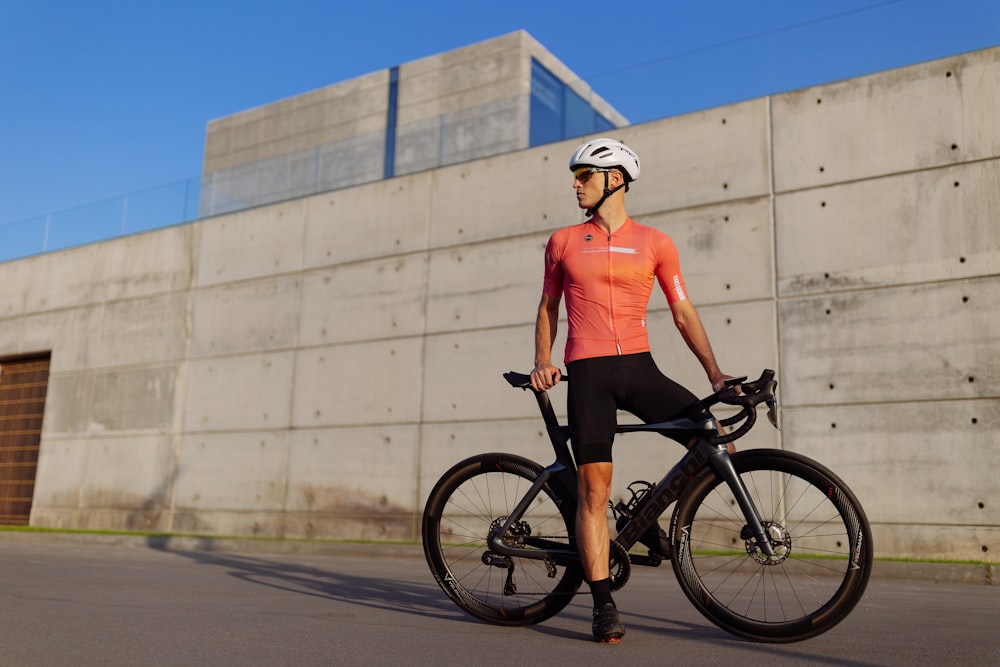 a man standing next to a bike in front of a building