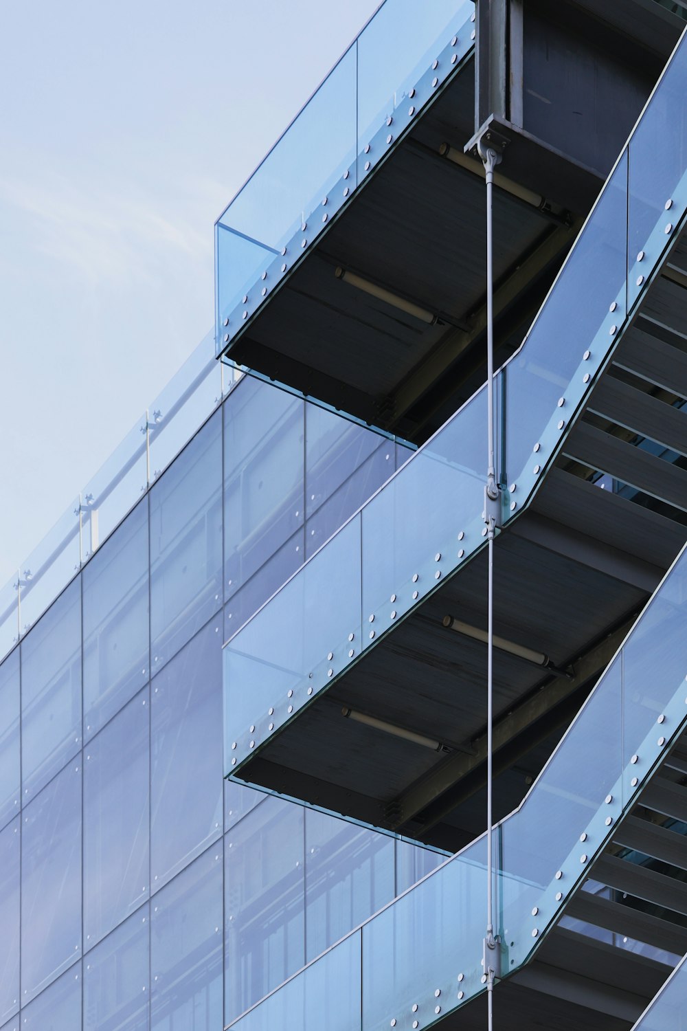 an airplane is flying by a building with glass balconies