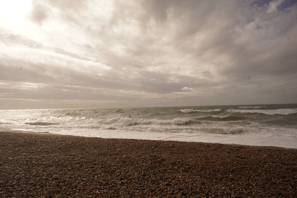 a sandy beach with waves coming in to shore