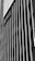 A black and white vertical striped wall features a sign with the word 'Netflix'. The stripes create a striking pattern and the sign is placed at an angle, adding depth to the image.