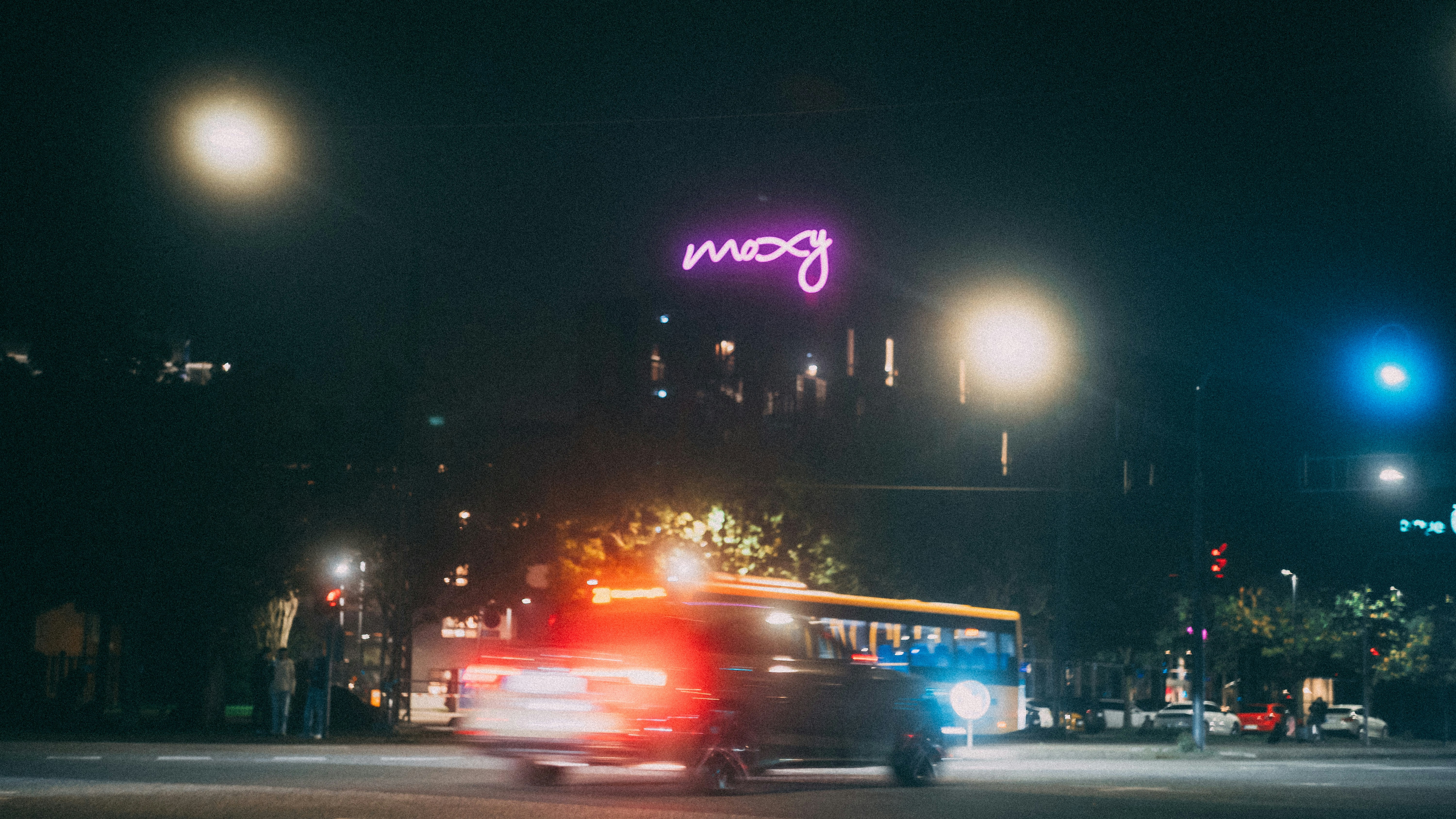 a bus driving down a street at night, 