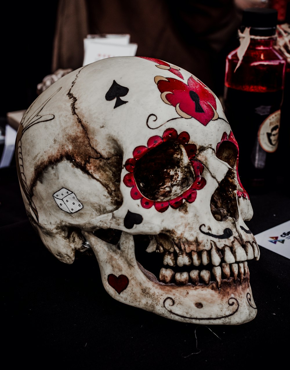 a skull with red flowers and hearts painted on it