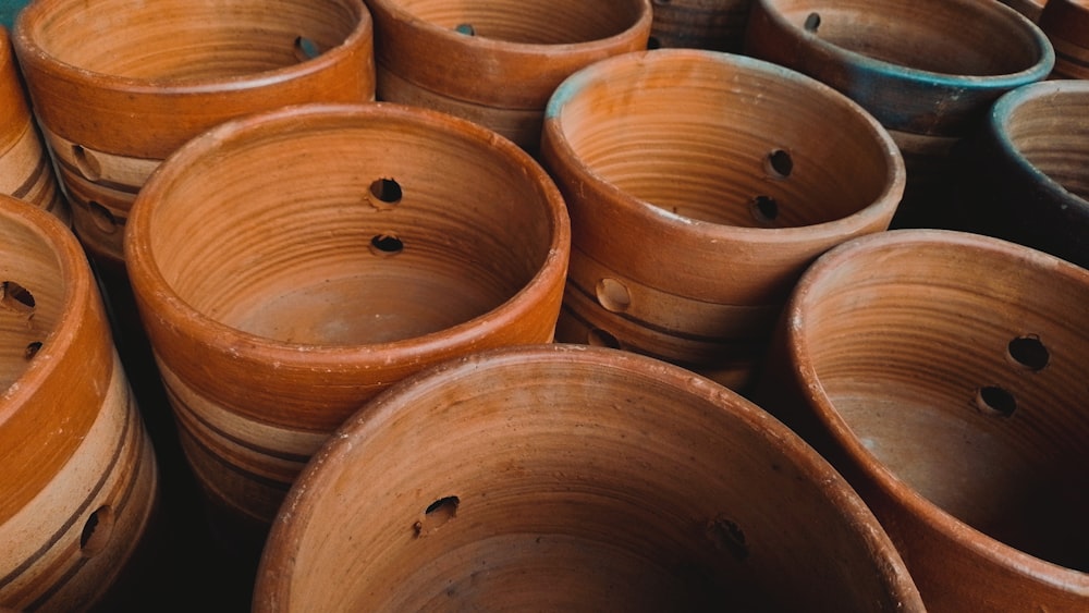 uma pilha de panelas de barro sentadas uma ao lado da outra