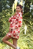 A model wearing a flowing outfit in a natural outdoor setting.