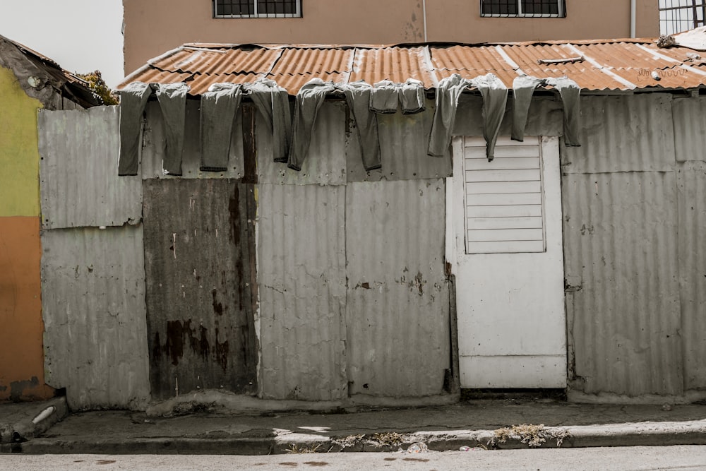 a run down building with clothes hanging on the roof