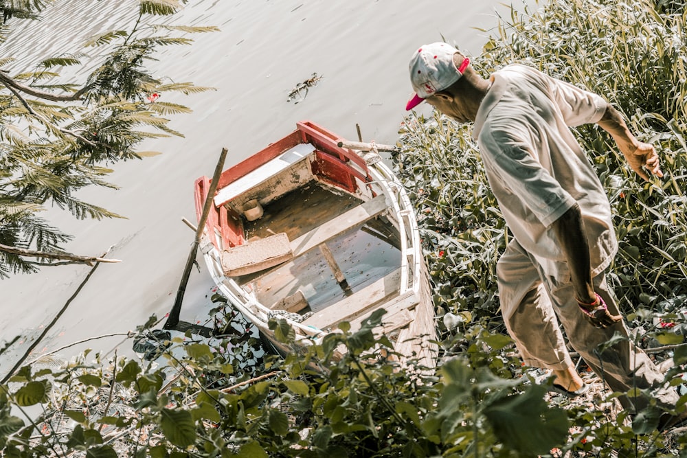 a man standing next to a boat on a body of water