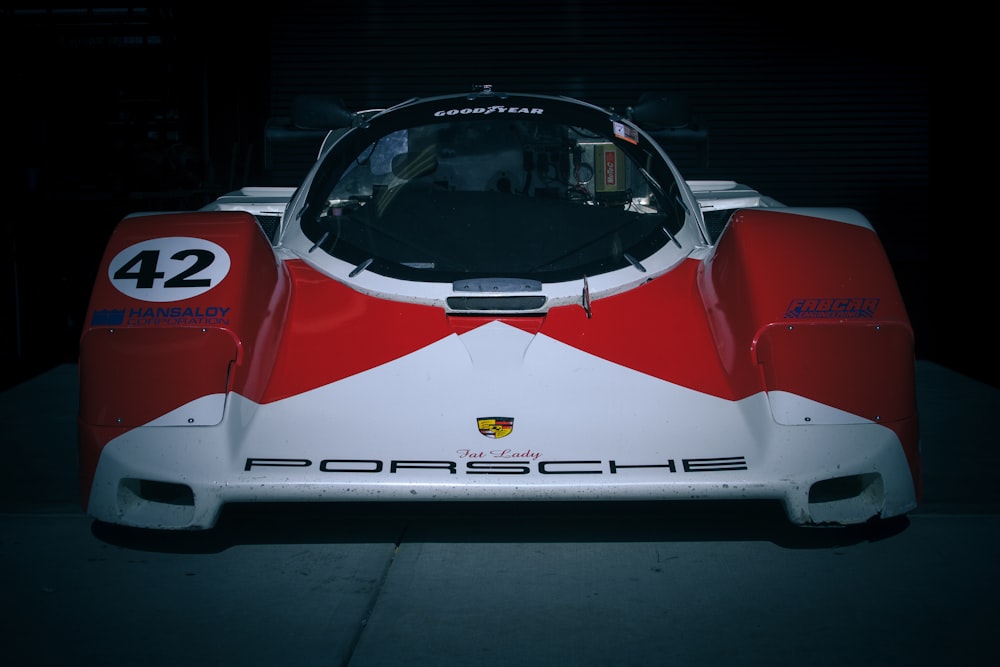 Un Porsche deportivo rojo y blanco estacionado en un garaje