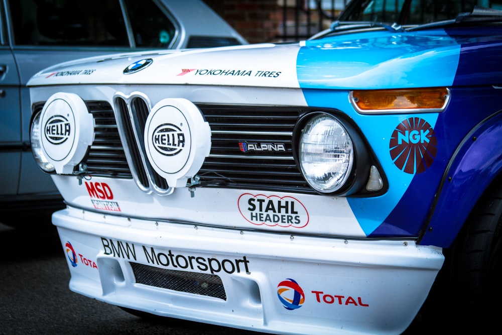 a close up of the front of a blue and white car