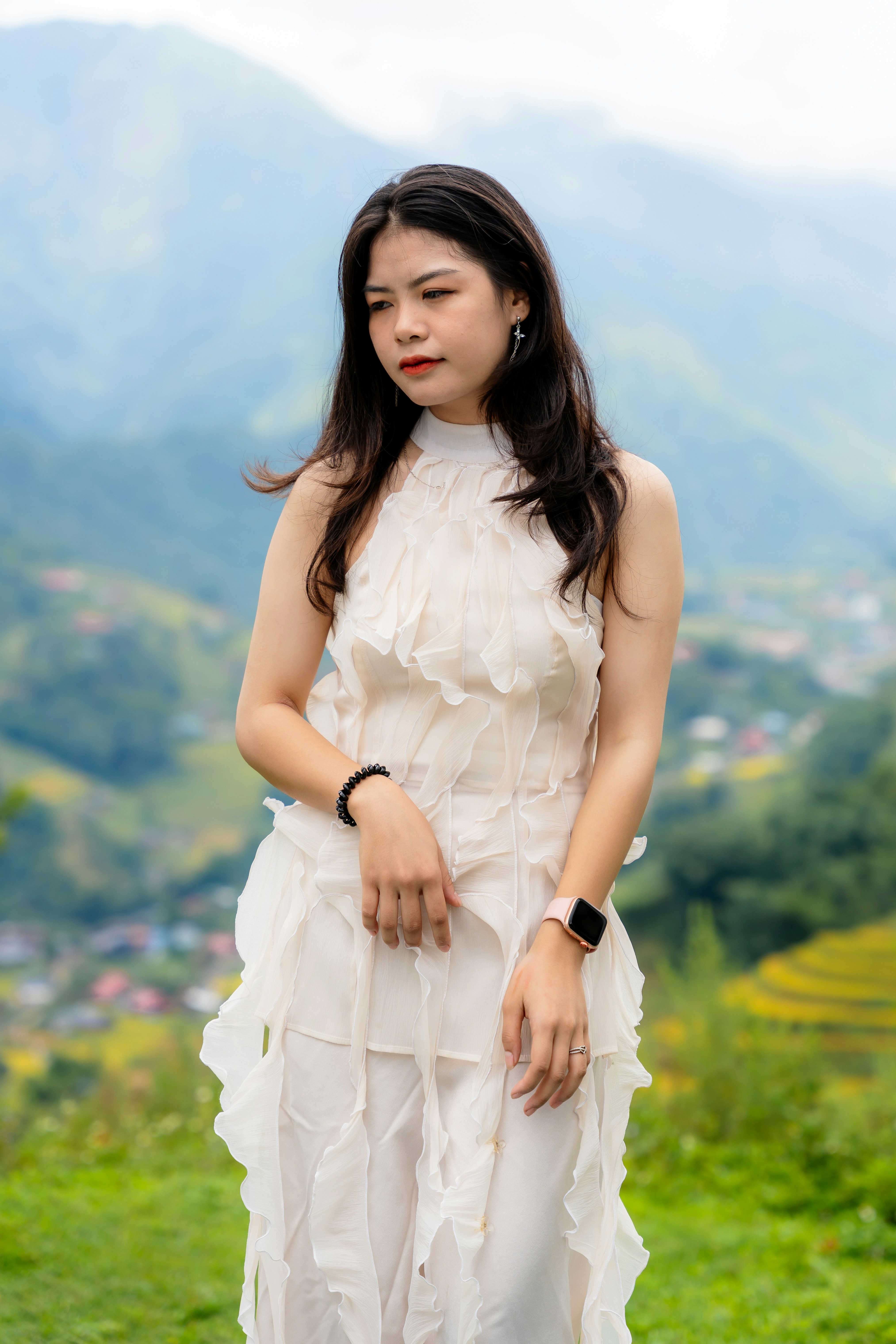 a woman in a white dress standing in a field