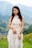 a woman in a white dress standing in a field