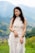 a woman in a white dress standing in a field