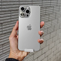 a person holding an iphone in front of a brick wall