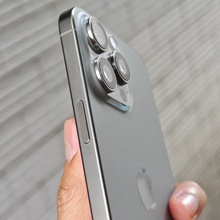 Hand holding an iPhone Pro in titanium