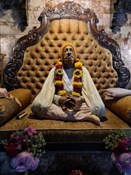 a statue of a man sitting on top of a couch