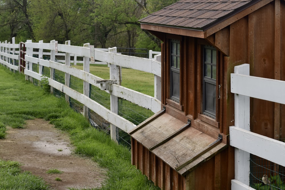 a white fence and a brown and white house