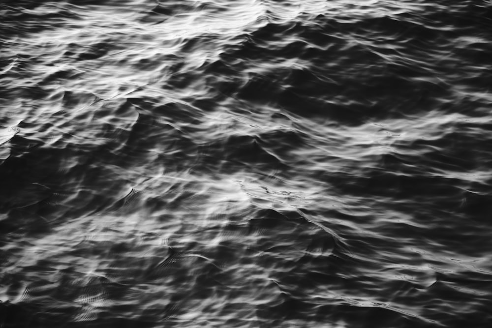 a black and white photo of waves in the water