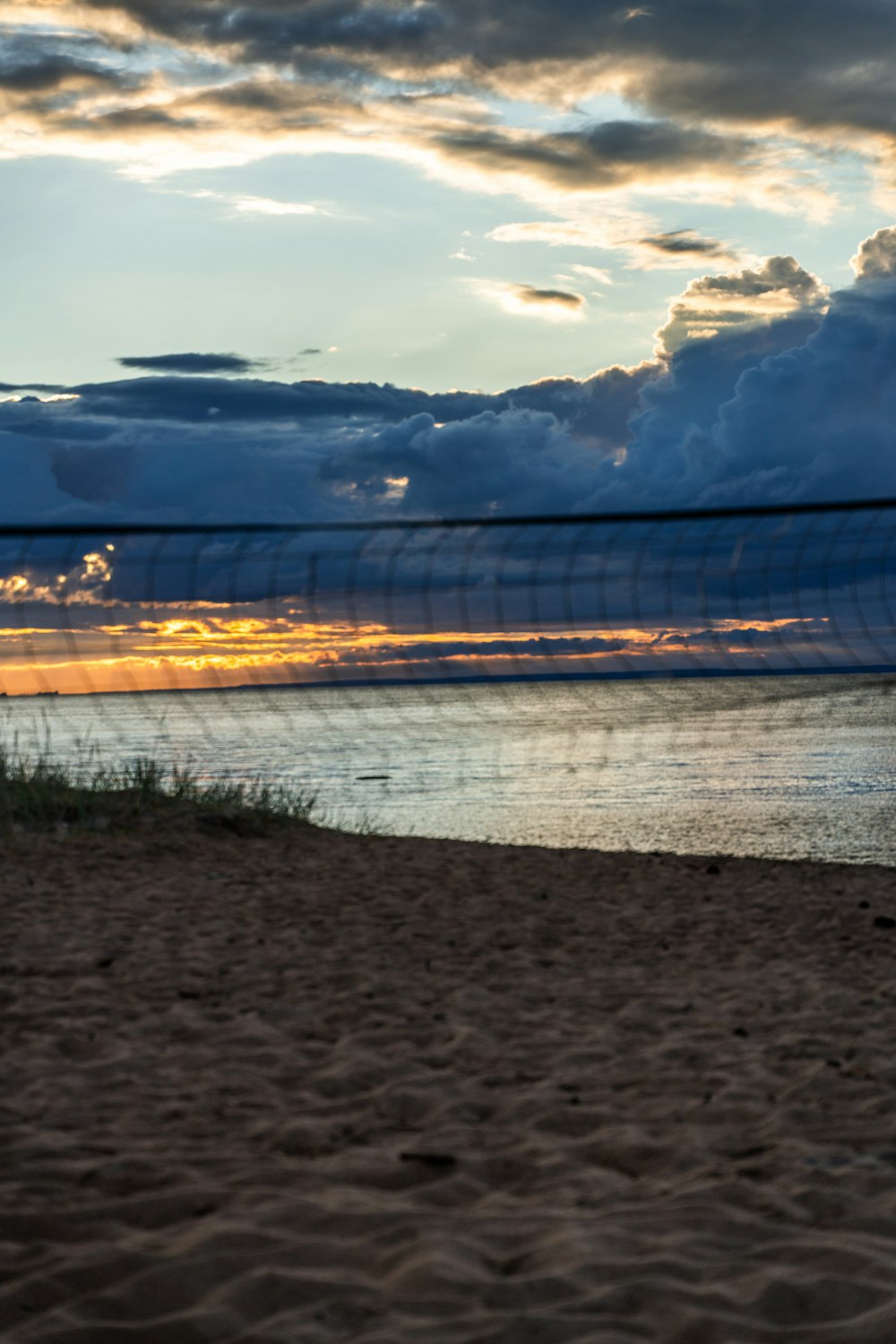 ein Strand mit einem Volleyballnetz und einem Gewässer