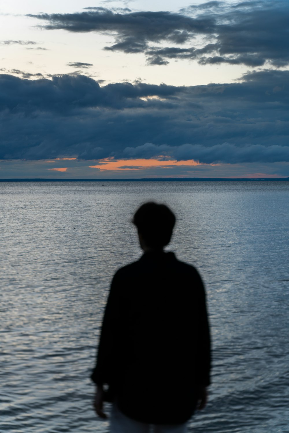 a man standing in front of a body of water