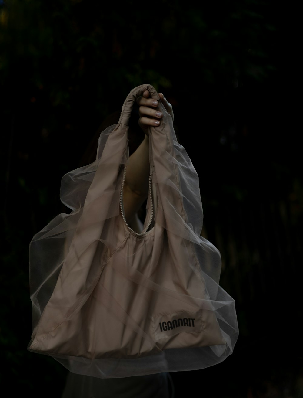 a person holding a bag with a veil over it