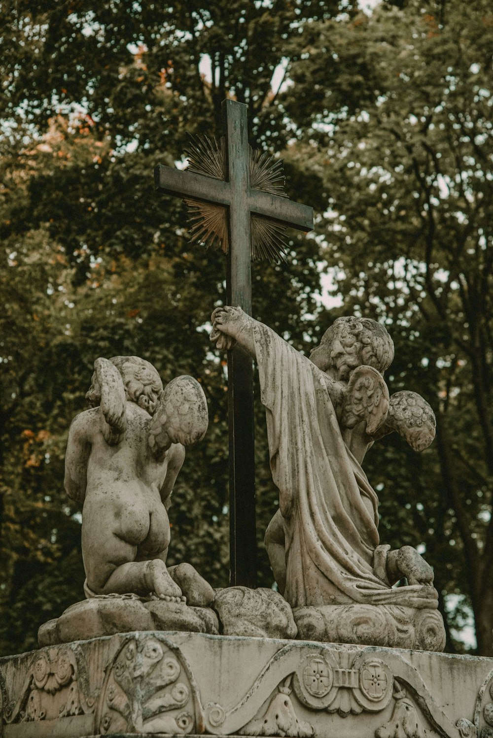 a statue of a person holding a cross